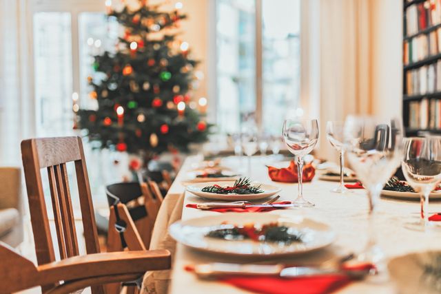 A photo of a table set for a holiday party with a Christmas tree in the background